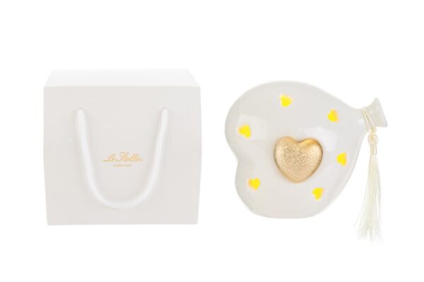 Cuore in porcellana a forma di palloncino con LED dorati, 11x8x11 cm, accanto a shopper bianco elegante.