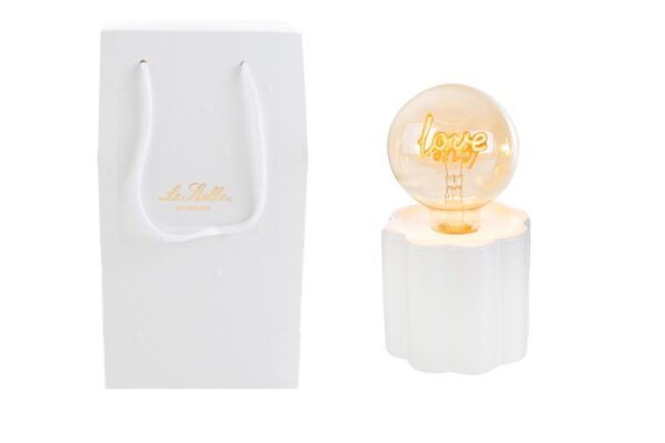 Lampada in porcellana bianca con LED "Love", dimensioni 10x18 cm, accompagnata da shopper elegante.