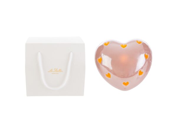 Cuore LED in porcellana rosa con piccoli cuori gialli, dimensioni 8x8xh.5cm, accanto a shopper bianco incluso nel prodotto.