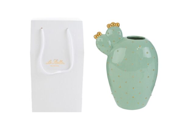Vaso in porcellana a forma di cactus verde con dettagli dorati, dimensioni 14x8xh.20 cm, accanto shopper bianco elegante.