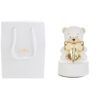 Carillon a forma di orsetto in porcellana bianca con fiocco dorato, 9xH14 cm, accanto a shopper bianco abbinato.