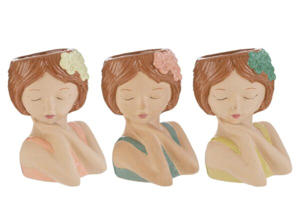 Tre vasi in ceramica a forma di ragazza con capelli castani e fiori colorati, disponibili in tre varianti. Dim: 17x16xh.23 cm.
