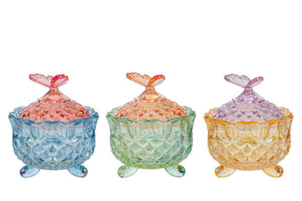 Tre scatole in vetro colorato con motivo farfalla sul coperchio, disponibili nei colori rosa, verde e giallo.