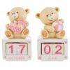 Due piccoli orsetti in resina rosa con calendario, uno tiene un’auto e l’altro una palla.