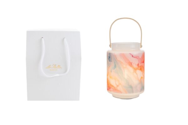 Lanterna in vetro effetto acquerello, dimensioni d.12xh.17cm, con shopper bianco incluso sullo sfondo.