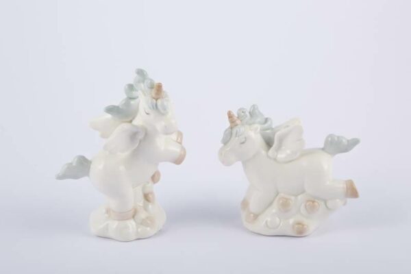 Due statuette di unicorni in porcellana celeste, con dettagli dorati, posizionati su basi decorative bianche.