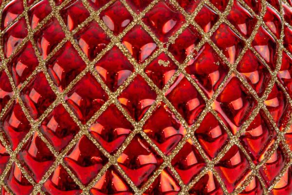 Dettaglio di una pallina di vetro rosso con decoro dorato, parte del set da 2, diametro 15 cm.