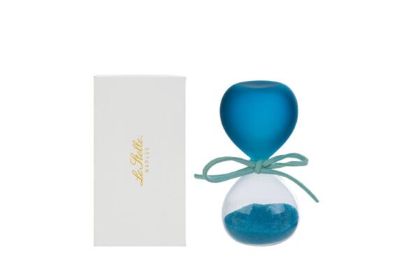 Clessidra in vetro celeste satinato con sabbia blu, altezza 8 cm, accanto ad astuccio bianco.